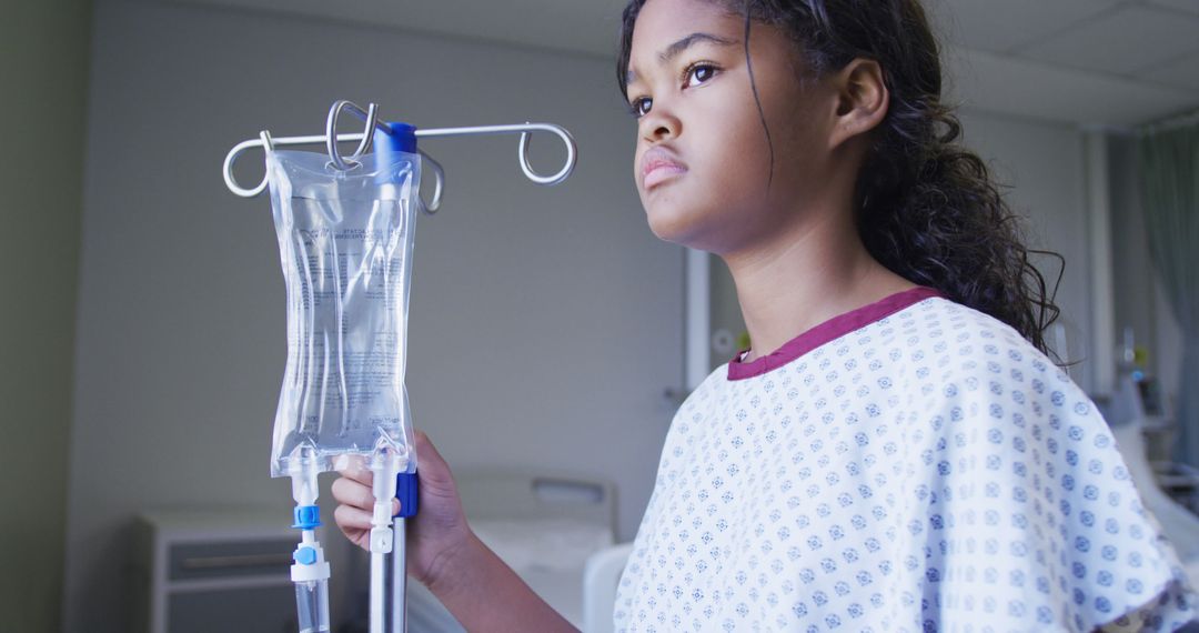 Biracial girl standing with drip bag in hospital room - Free Images, Stock Photos and Pictures on Pikwizard.com