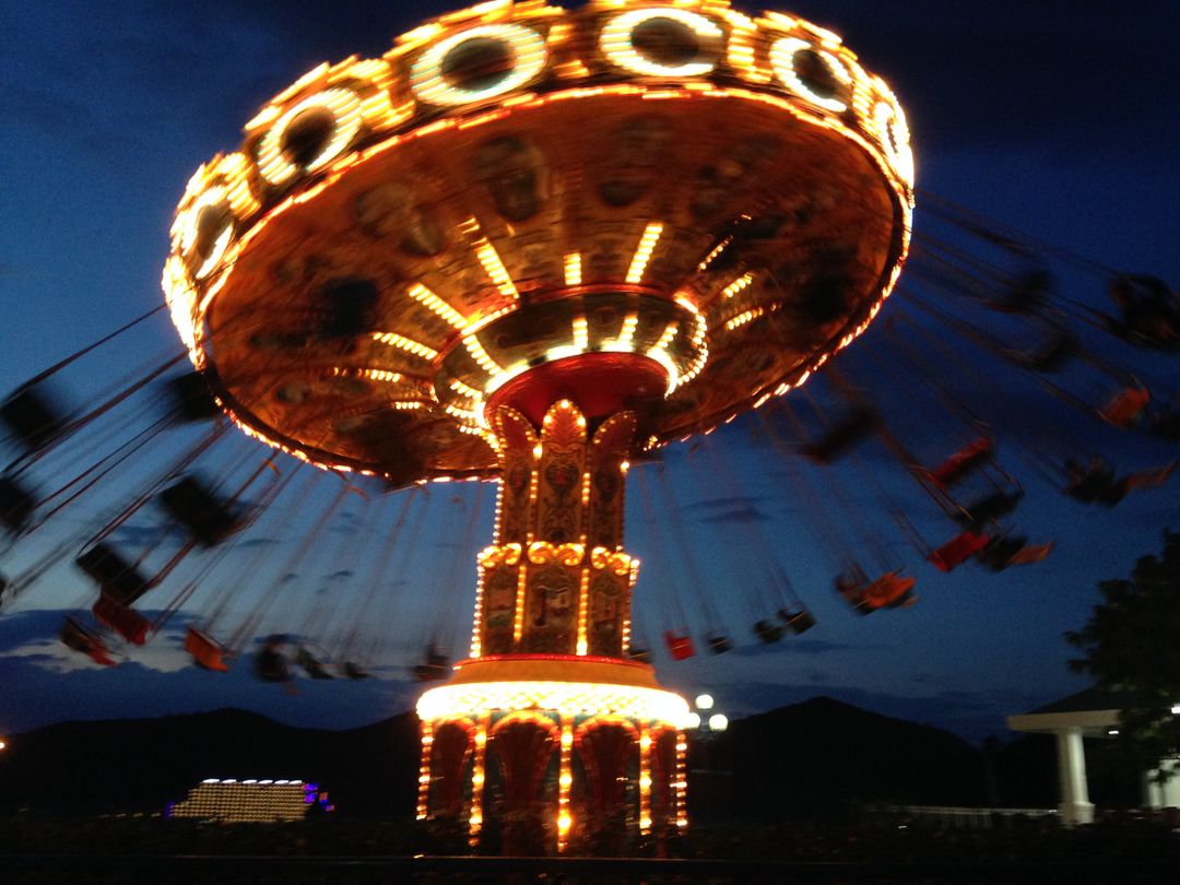 Illuminated Spinning Carousel at Night in Amusement Park - Free Images, Stock Photos and Pictures on Pikwizard.com