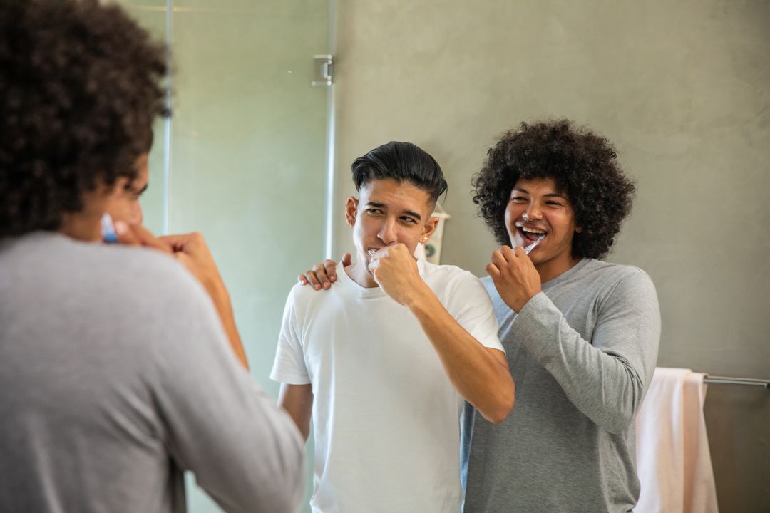 Roommates Smiling While Brushing Teeth Together in Bathroom