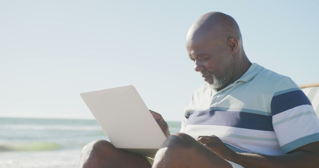 Retired African American Man Working on Laptop at Beach - Free Images, Stock Photos and Pictures on Pikwizard.com