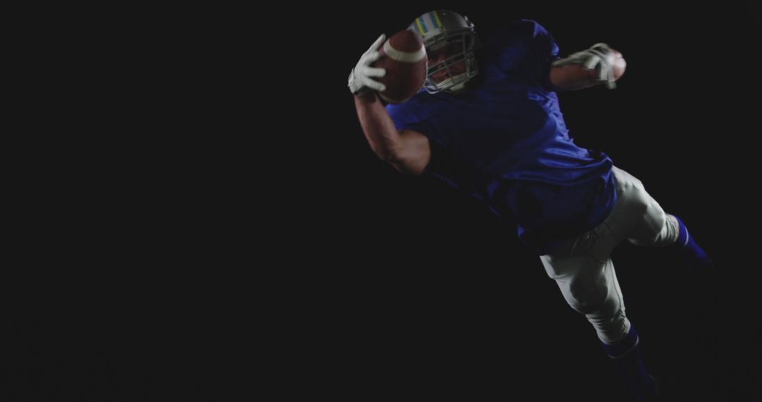 Football Player Catching Ball Mid-Air on Black Background - Free Images, Stock Photos and Pictures on Pikwizard.com