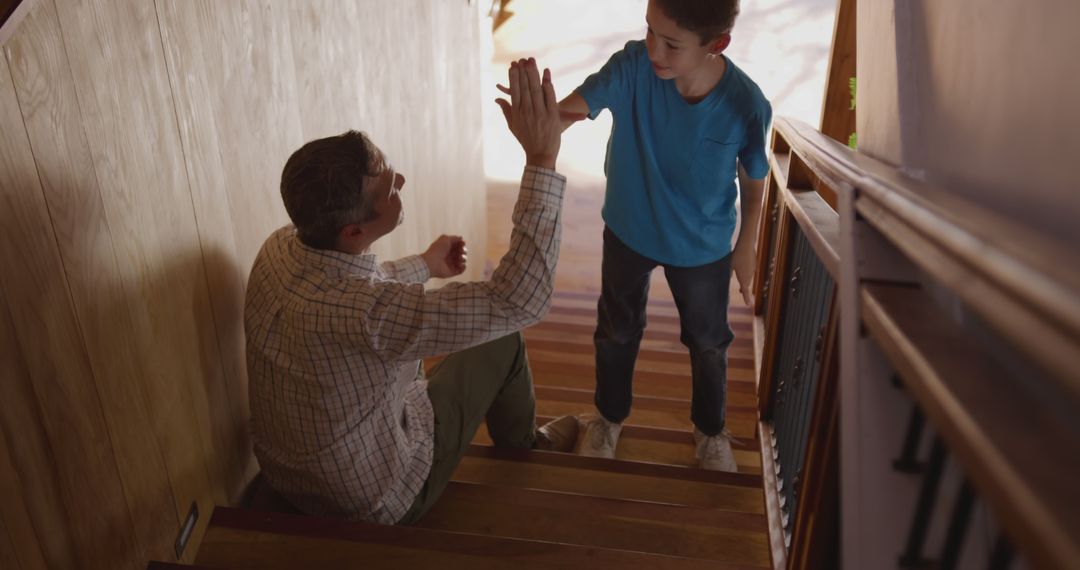 Father and Son Sharing a High-Five on Stairs - Free Images, Stock Photos and Pictures on Pikwizard.com