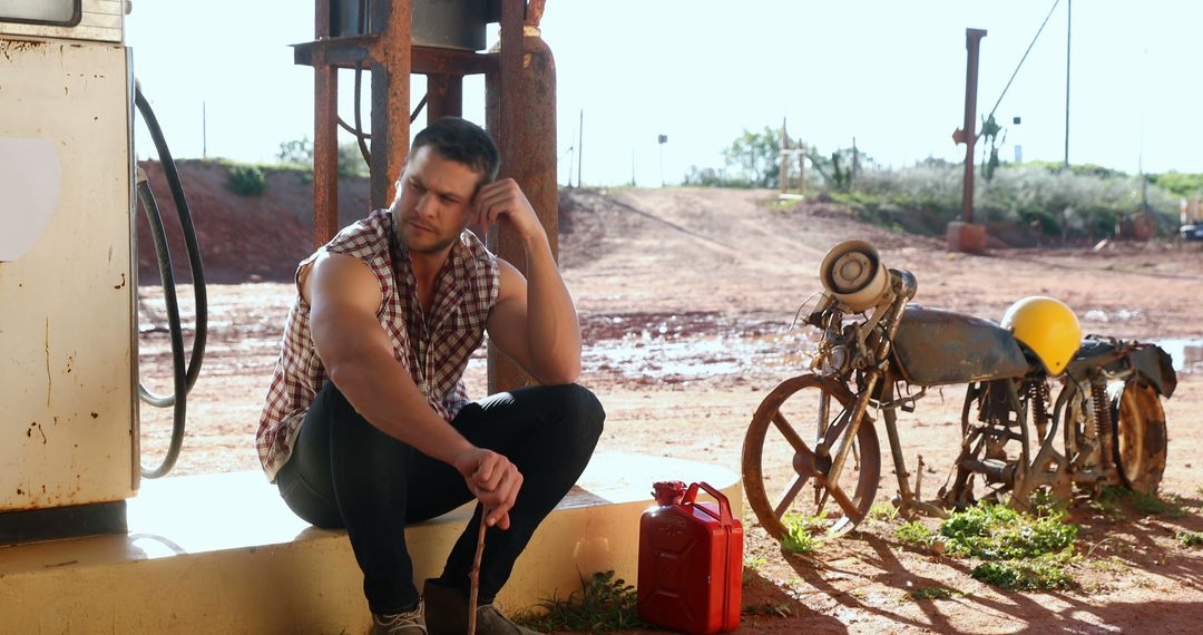 Man Sitting by Abandoned Gas Station in Rural Area - Free Images, Stock Photos and Pictures on Pikwizard.com