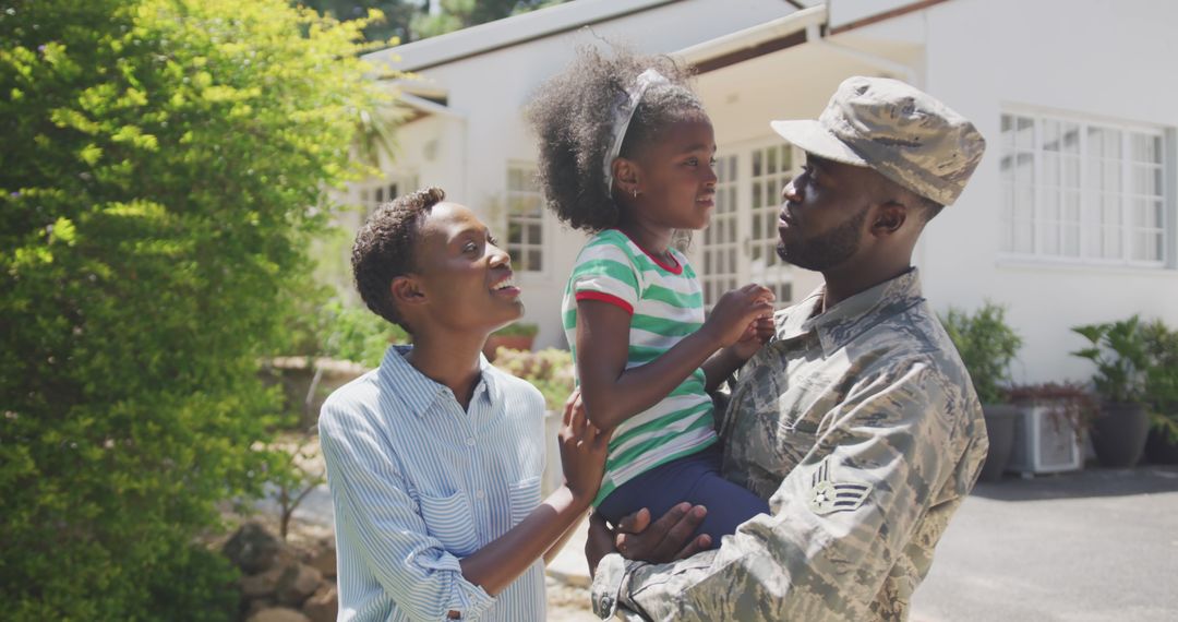 Happy african american male soldier and his family embracing and smiling outside the house - Free Images, Stock Photos and Pictures on Pikwizard.com