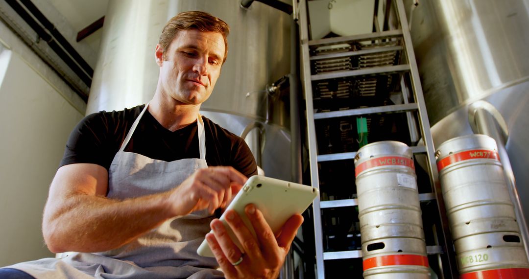 Brewery Worker Using Digital Tablet in Brewery Facility - Free Images, Stock Photos and Pictures on Pikwizard.com