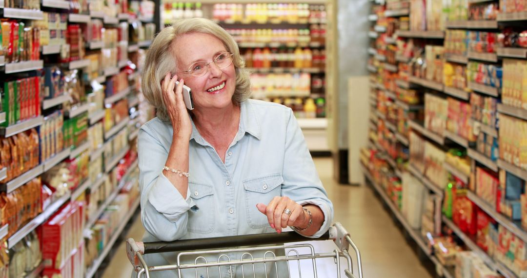 Senior Woman Shopping While Talking on Mobile Phone in Grocery Store Aisle - Free Images, Stock Photos and Pictures on Pikwizard.com