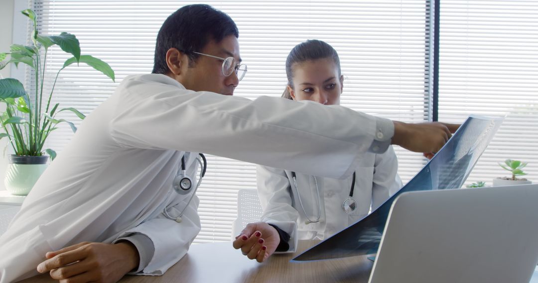 Male and Female Doctors Analyzing X-ray in Modern Medical Office - Free Images, Stock Photos and Pictures on Pikwizard.com