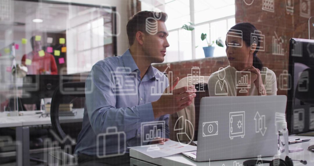 Collaborating colleagues analyzing business data on laptop in modern open-plan office