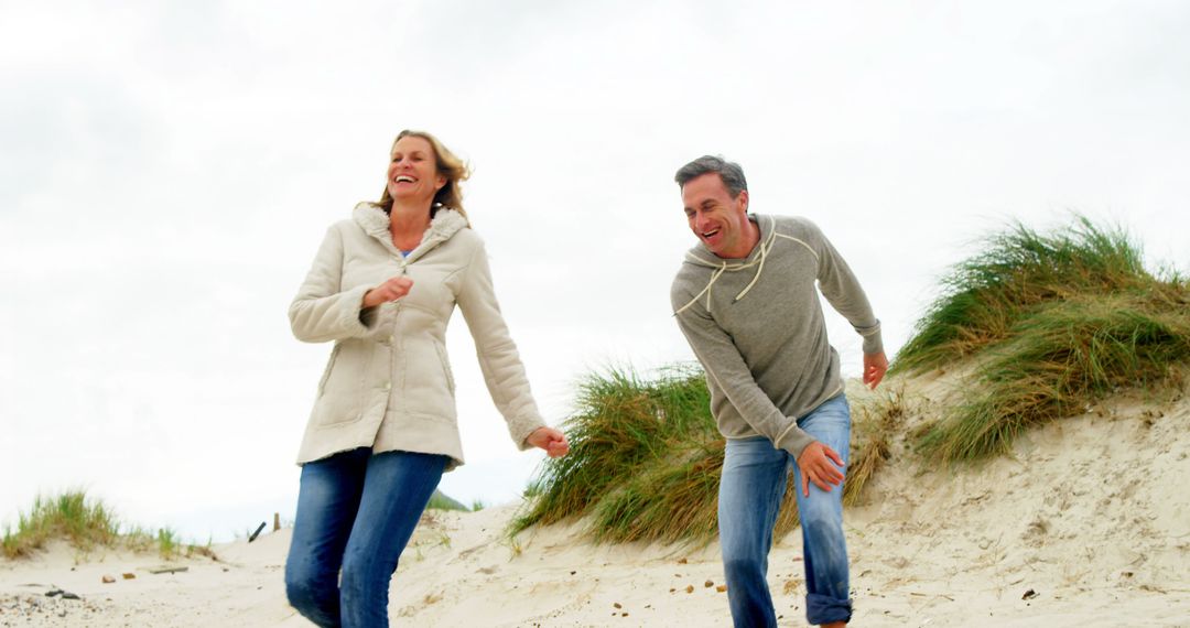 Happy Mature Couple Enjoying a Beach Walk - Free Images, Stock Photos and Pictures on Pikwizard.com