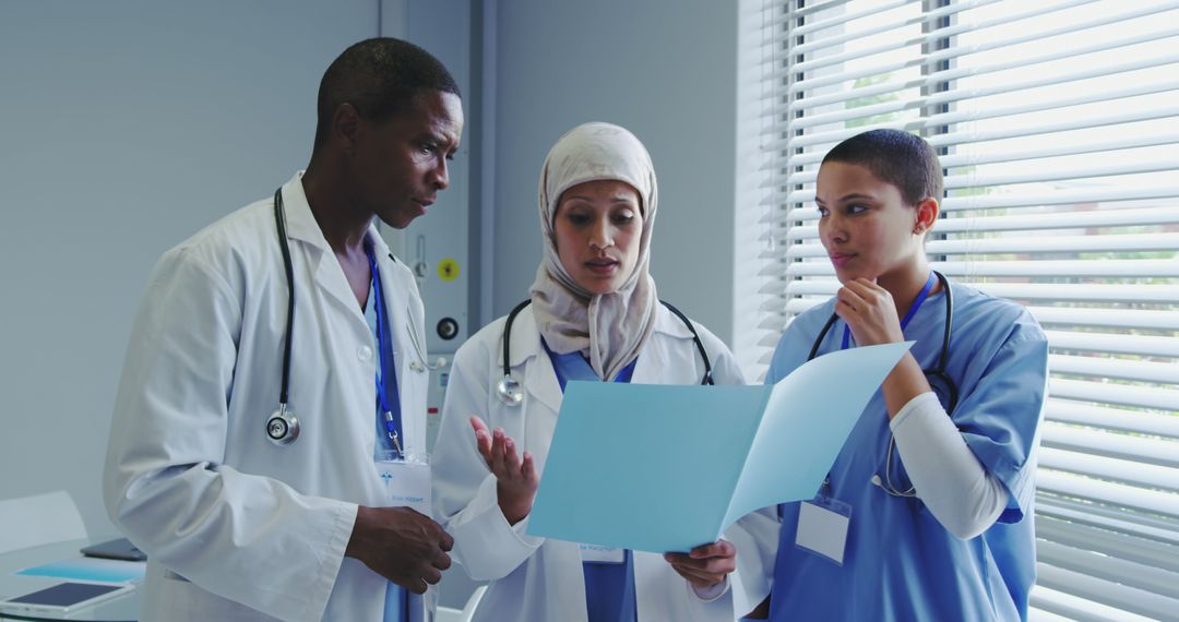 Diverse Medical Team Discussing Patient Records in Clinic - Free Images, Stock Photos and Pictures on Pikwizard.com