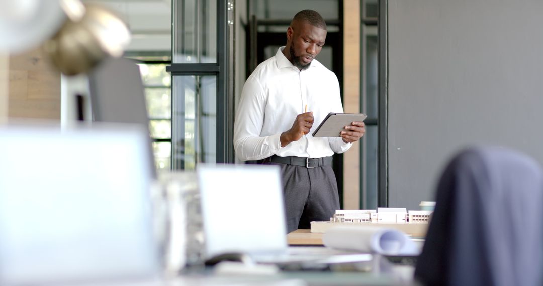 Businessman Using Tablet in Modern Office Workspace