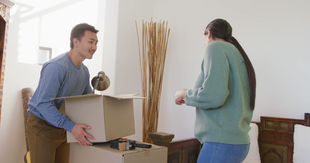 Couple Moving into New Home With Boxes in Living Room - Free Images, Stock Photos and Pictures on Pikwizard.com