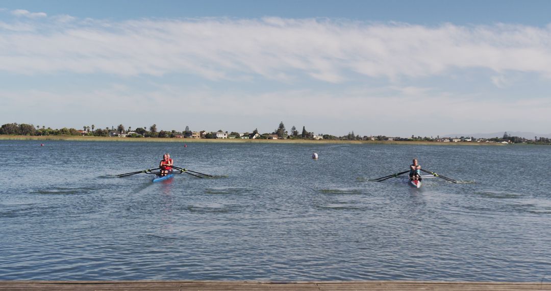 Two Rowers on Serene Lake on Clear Day with Blue Sky - Free Images, Stock Photos and Pictures on Pikwizard.com