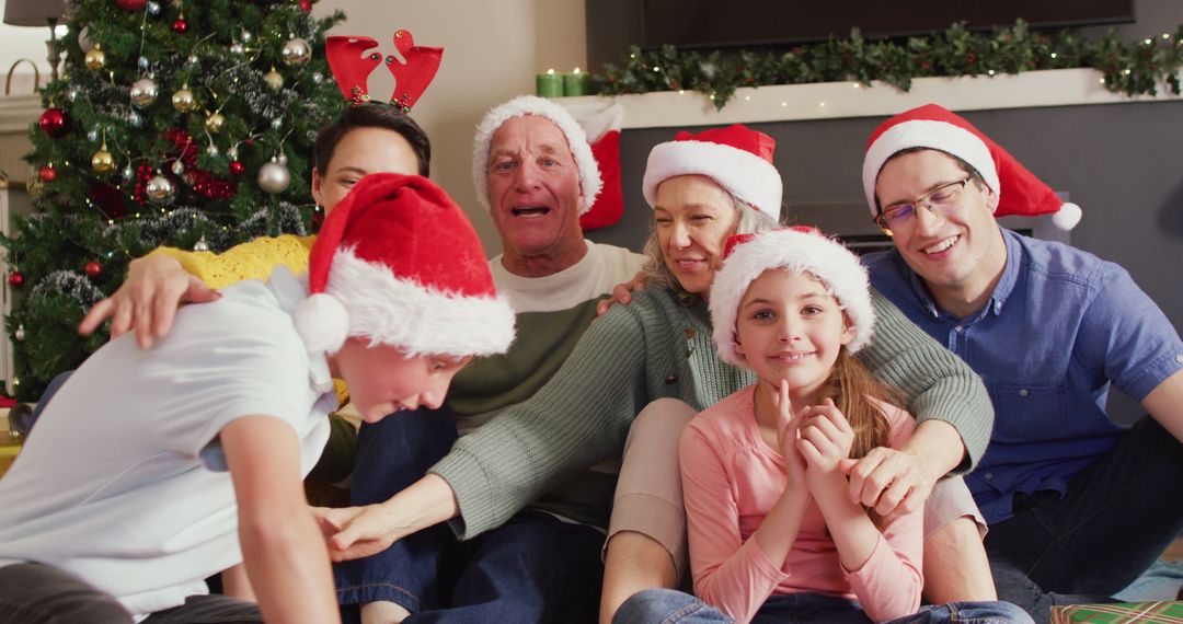 Family Celebrating Christmas Together at Home with Santa Hats - Free Images, Stock Photos and Pictures on Pikwizard.com