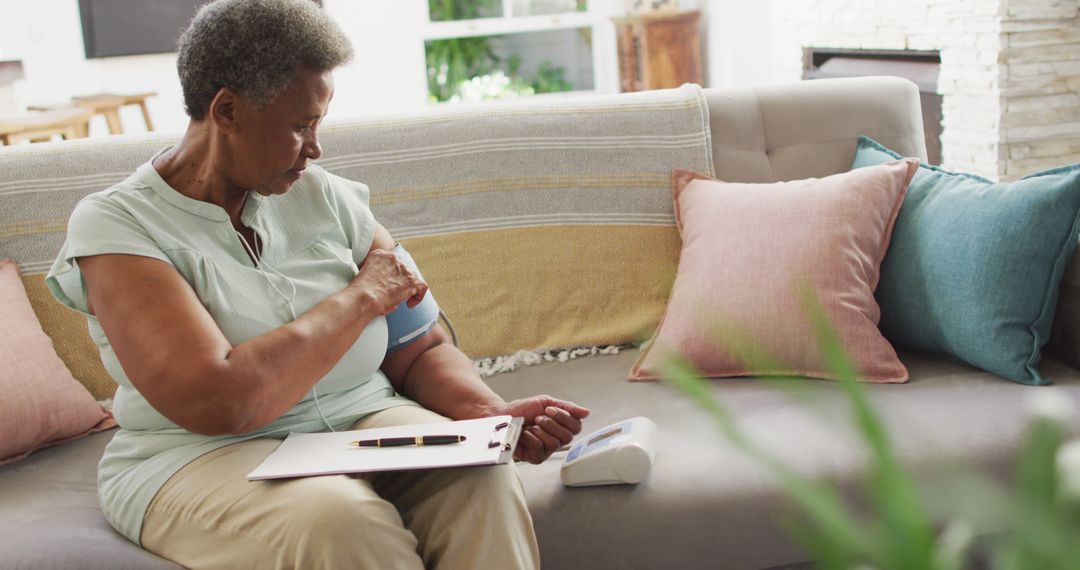 Older Woman Checking Blood Pressure on Sofa - Free Images, Stock Photos and Pictures on Pikwizard.com