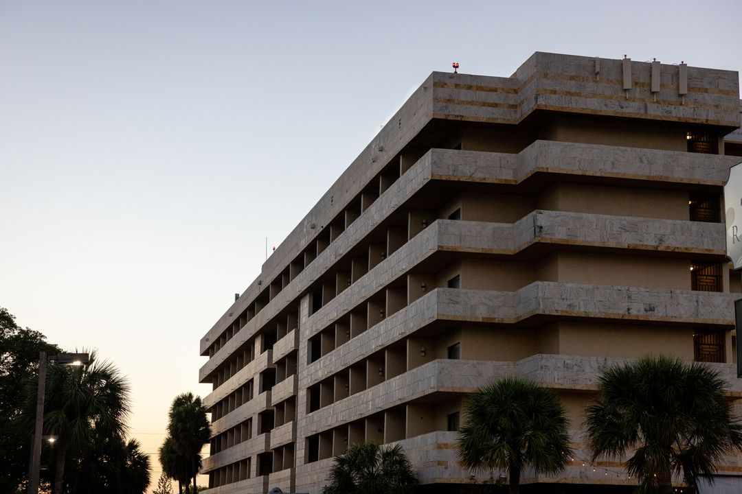 Urban concrete building design at dusk with palm trees