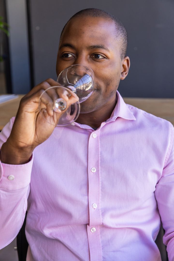 Sophisticated Man Sipping Beverage in Elegant Cafe Setting