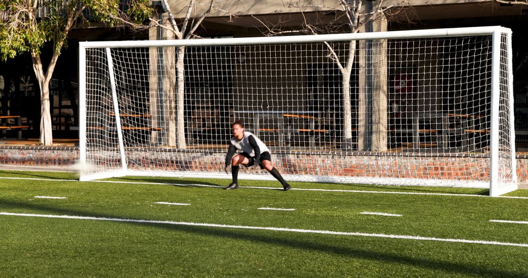 Goalkeeper Standing Alert in Front of Soccer Goal During Practice