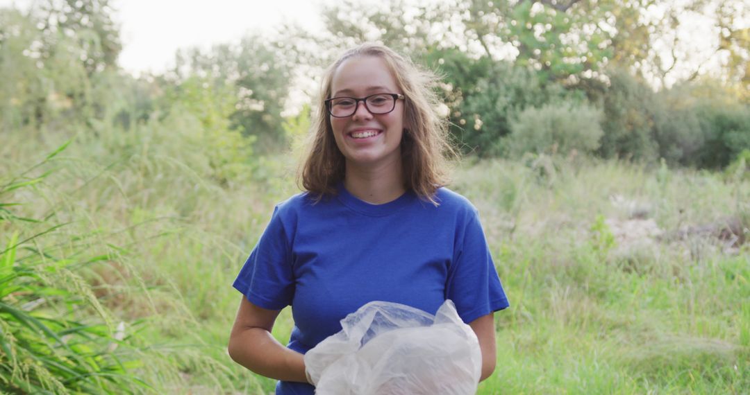 Smiling Young Woman Cleaning Park with Trash Bag - Free Images, Stock Photos and Pictures on Pikwizard.com