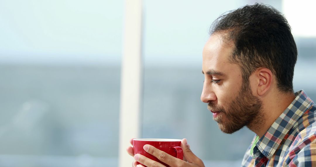 Relaxed Man Sipping Hot Drink Near Window - Free Images, Stock Photos and Pictures on Pikwizard.com