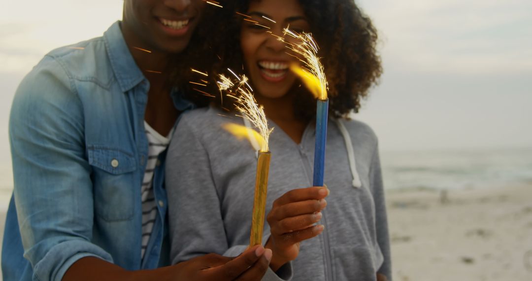 Joyful African American Couple Celebrating on Beach with Sparklers