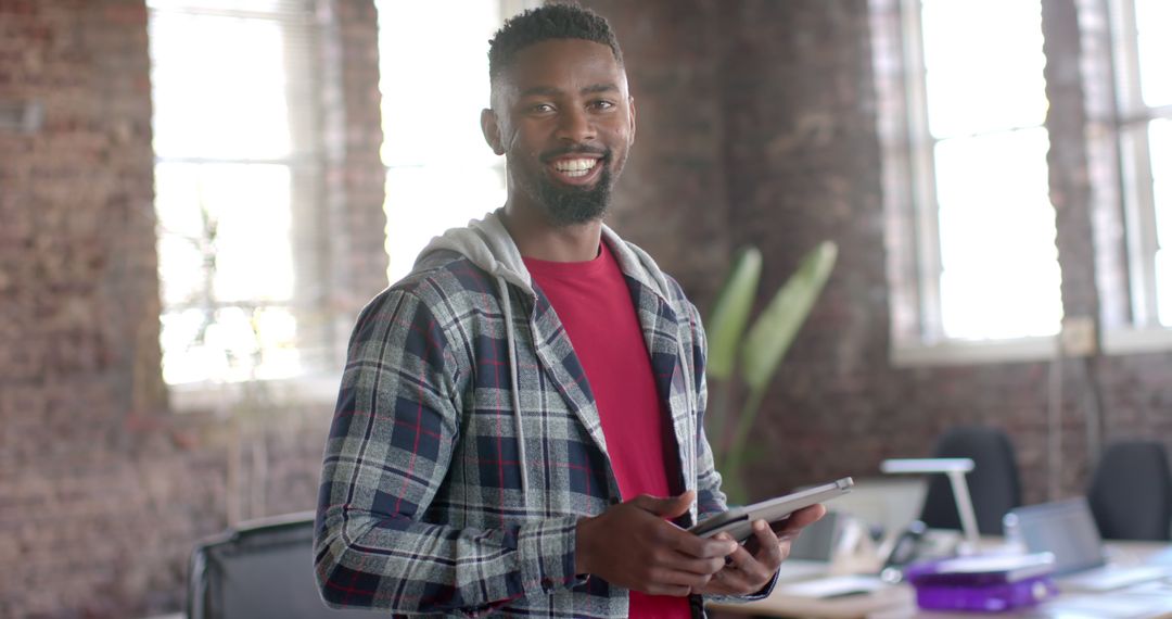 Smiling African American Man Using Tablet in Modern Office - Free Images, Stock Photos and Pictures on Pikwizard.com