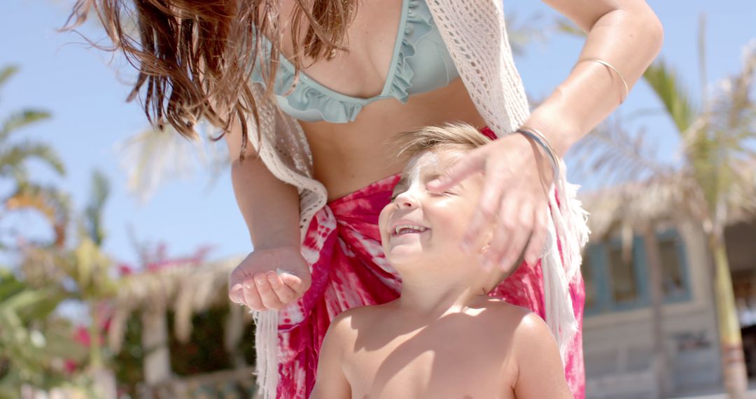 Mother Applying Sunscreen to Smiling Child at Beach - Free Images, Stock Photos and Pictures on Pikwizard.com