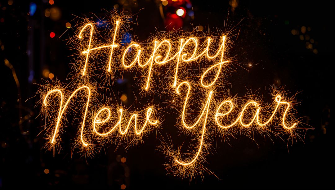 Writing Happy New Year with Handheld Sparklers Forming Golden Spark Trails, Festive Bokeh