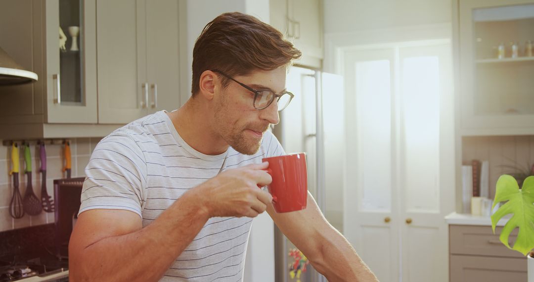 Man Drinking Coffee in Modern Kitchen During Morning Sunlight - Free Images, Stock Photos and Pictures on Pikwizard.com