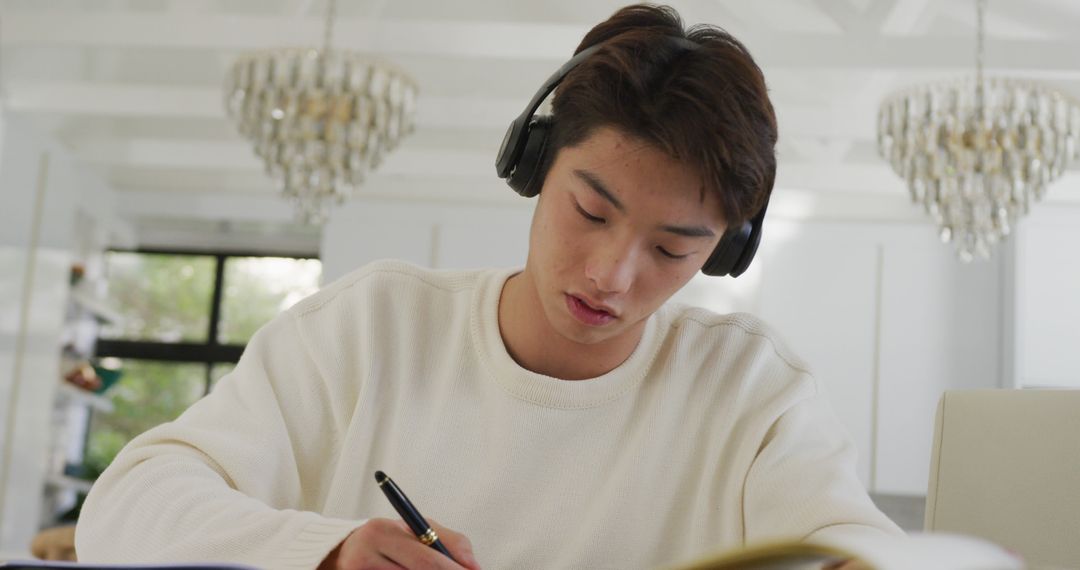 Young Man Wearing Headphones Studying in Modern Home - Free Images, Stock Photos and Pictures on Pikwizard.com