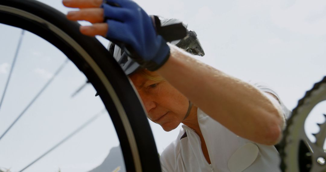 Senior Female Cyclist Fixing Bicycle Tire Outdoors - Free Images, Stock Photos and Pictures on Pikwizard.com