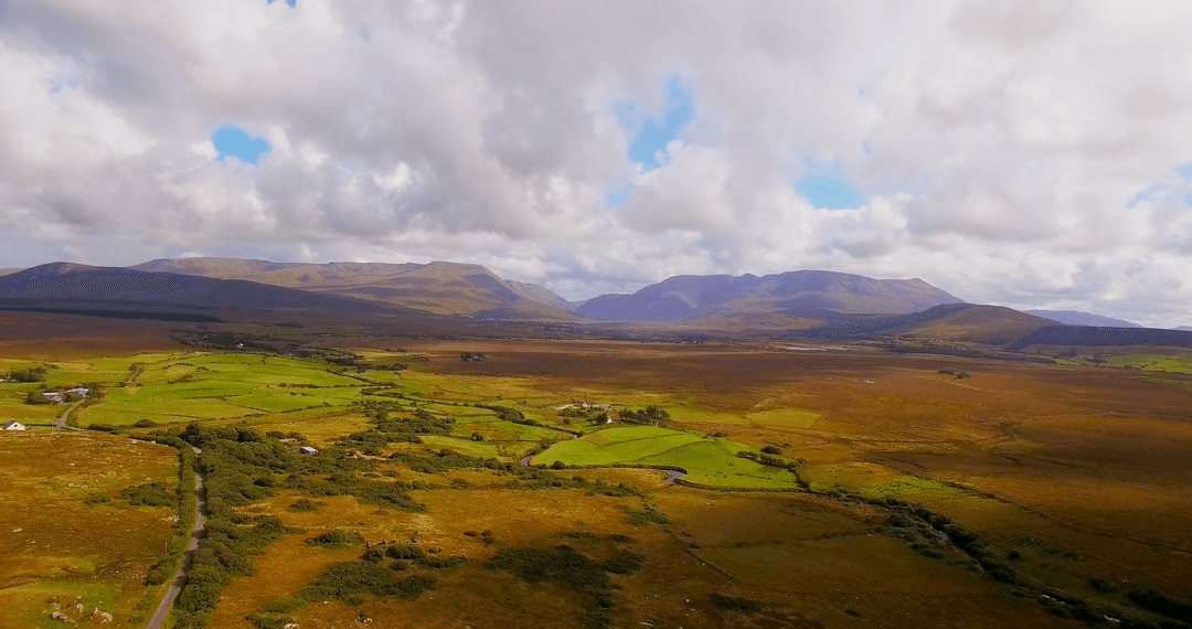 Countryside Landscape with Rolling Hills Under Cloudy Sky