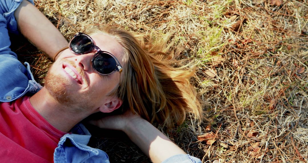 Relaxed Young Man with Sunglasses Lying on Ground in Forest - Free Images, Stock Photos and Pictures on Pikwizard.com