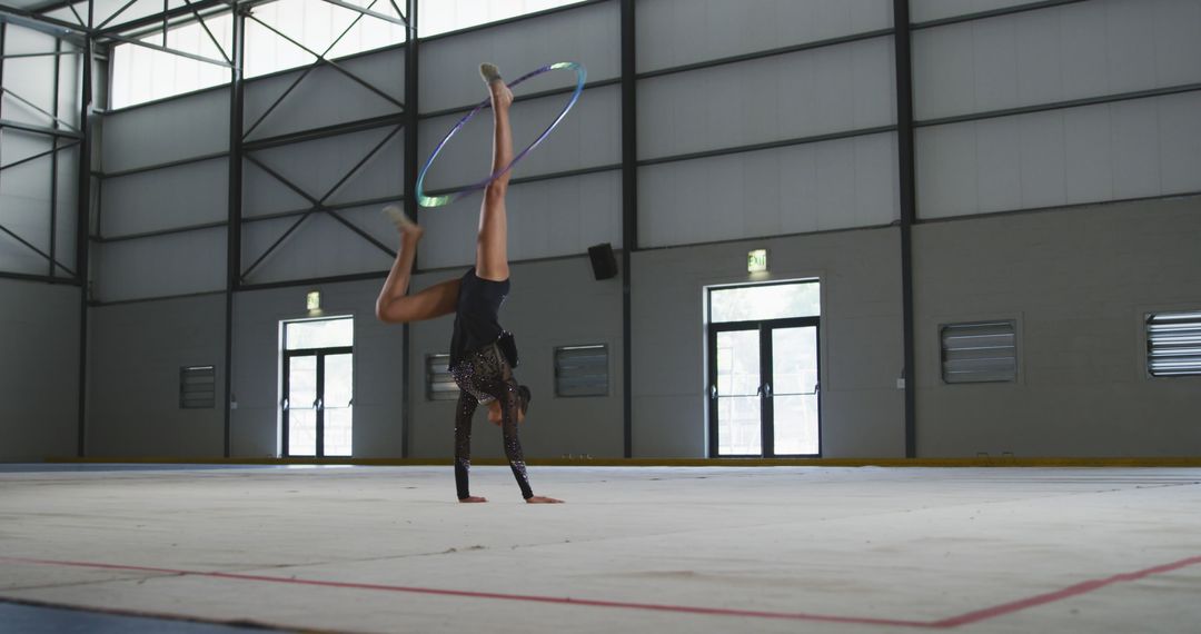 Female Athlete Performing Gymnastic Hoop Routine in Indoor Arena - Free Images, Stock Photos and Pictures on Pikwizard.com