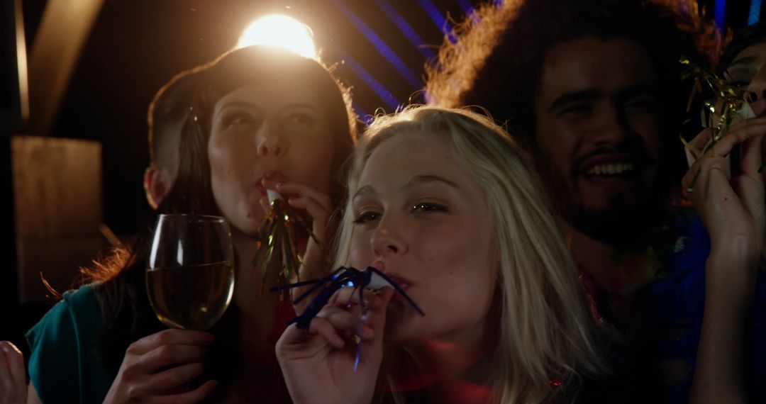 Energetic Group Celebrating at Party Blowouts and Joyful Expressions