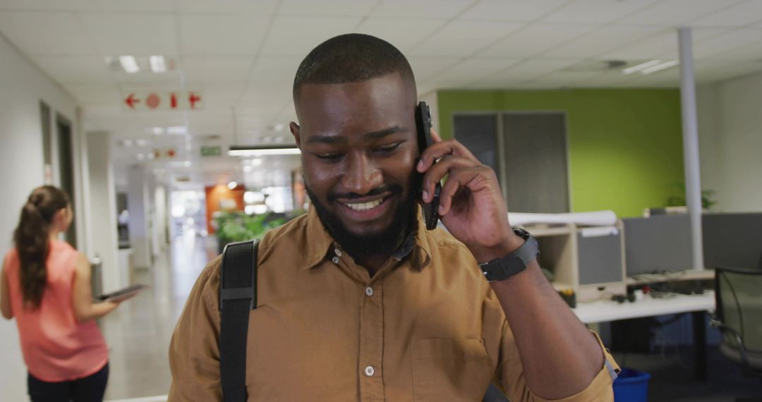 Professional in Modern Office Talking on Smartphone While Walking