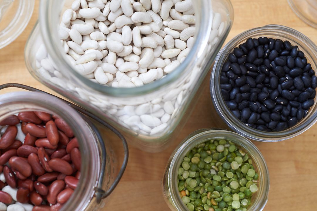 Assorted Beans and Lentils in Glass Jars on Wooden Surface