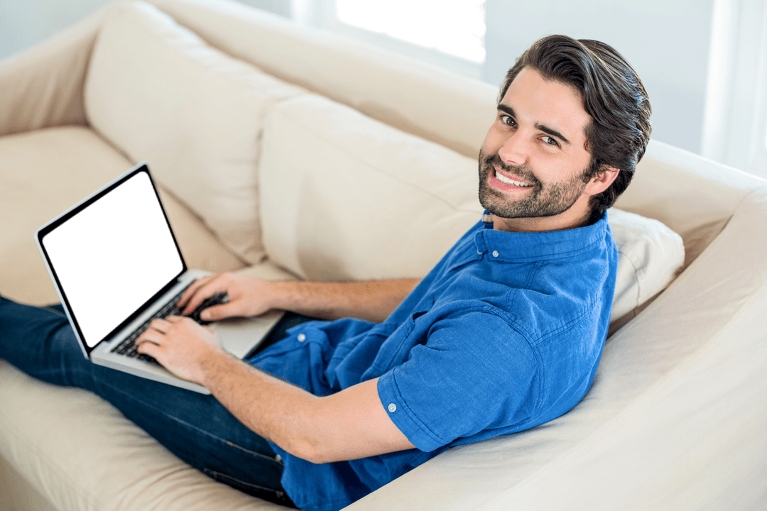 Smiling Man Using Laptop on Comfortable Homely Sofa