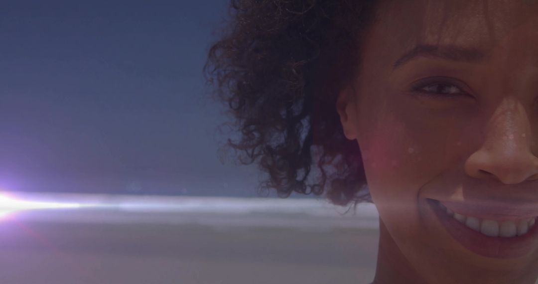 Joyful Woman with Natural Curls Enjoying Sunny Beach Day