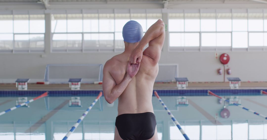 Male Swimmer Stretching Before Swim in Indoor Pool - Free Images, Stock Photos and Pictures on Pikwizard.com