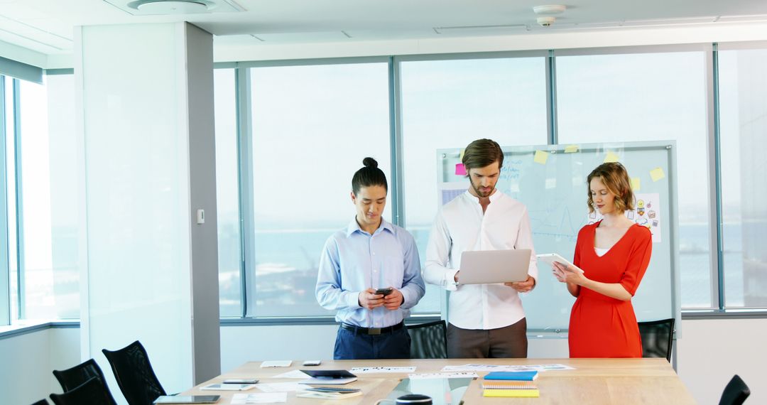 Business Team Collaborating with Devices in Bright Office Environment