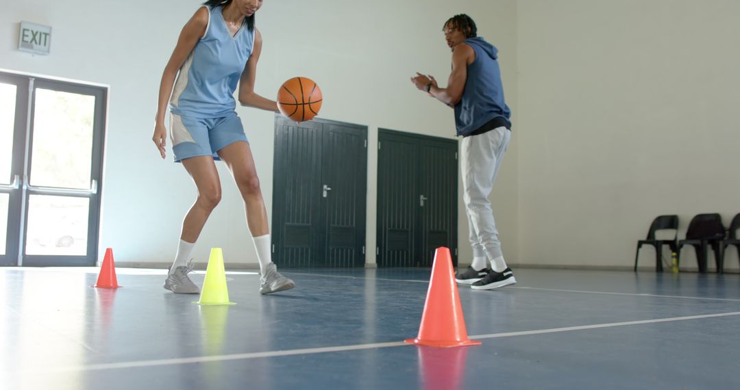 Coach Guiding Athlete in Basketball Dribbling Practice