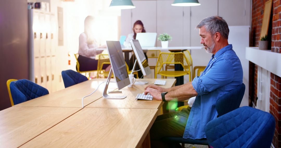 Modern Shared Workspace with Mature Professional Using Desktop Computer - Free Images, Stock Photos and Pictures on Pikwizard.com