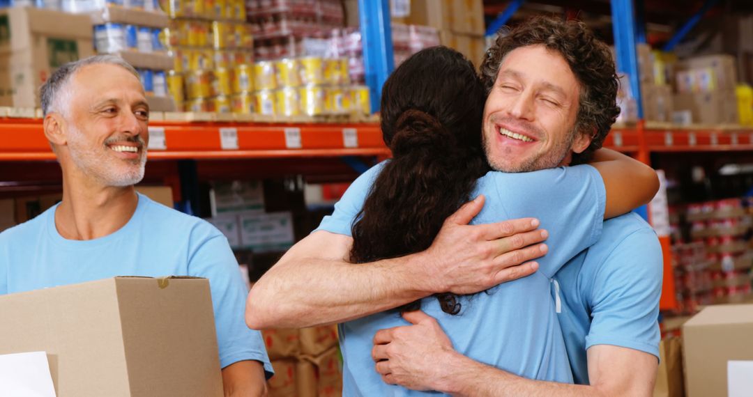 Volunteers Hugging with Boxes in Warehouse Setting - Free Images, Stock Photos and Pictures on Pikwizard.com