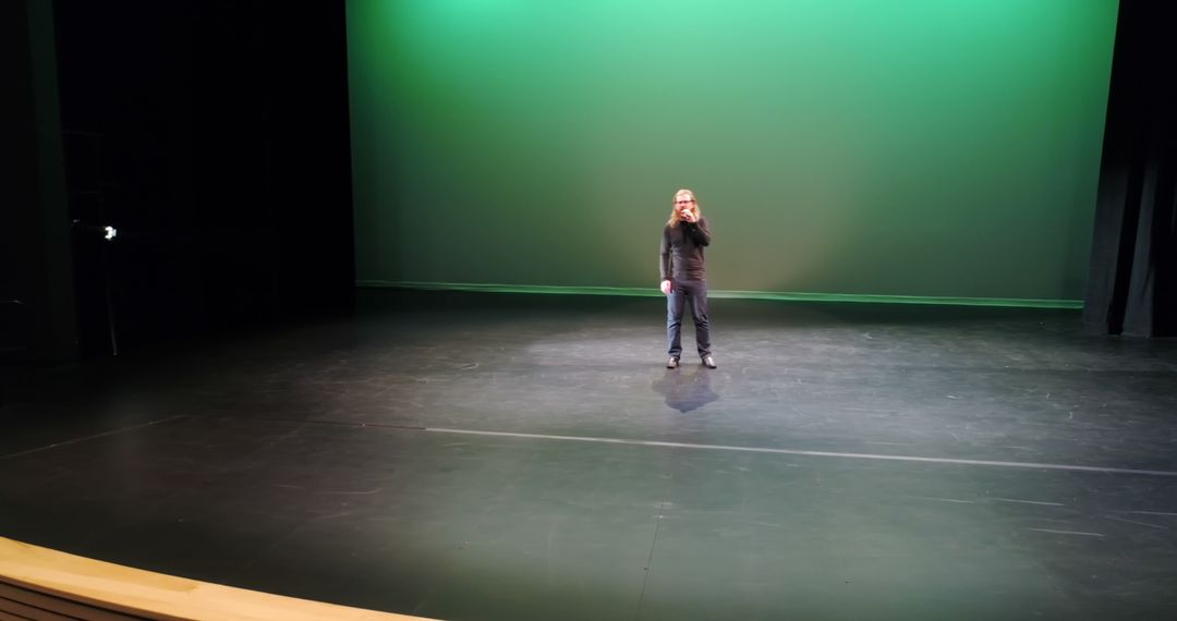Performer Rehearsing on Stage with Green Screen Background