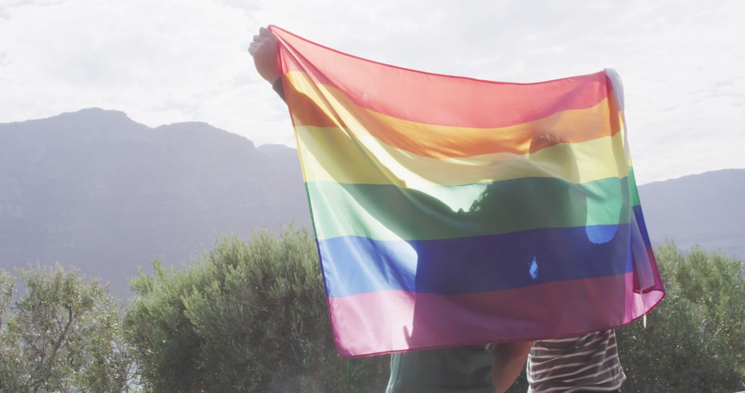 Couple Holding Rainbow Flag in Scenic Outdoor Location - Free Images, Stock Photos and Pictures on Pikwizard.com