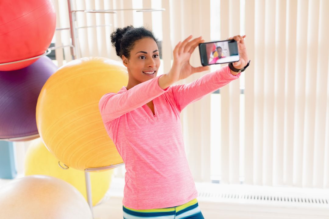 Woman Taking Selfie in Gym with Exercise Balls - Free Images, Stock Photos and Pictures on Pikwizard.com