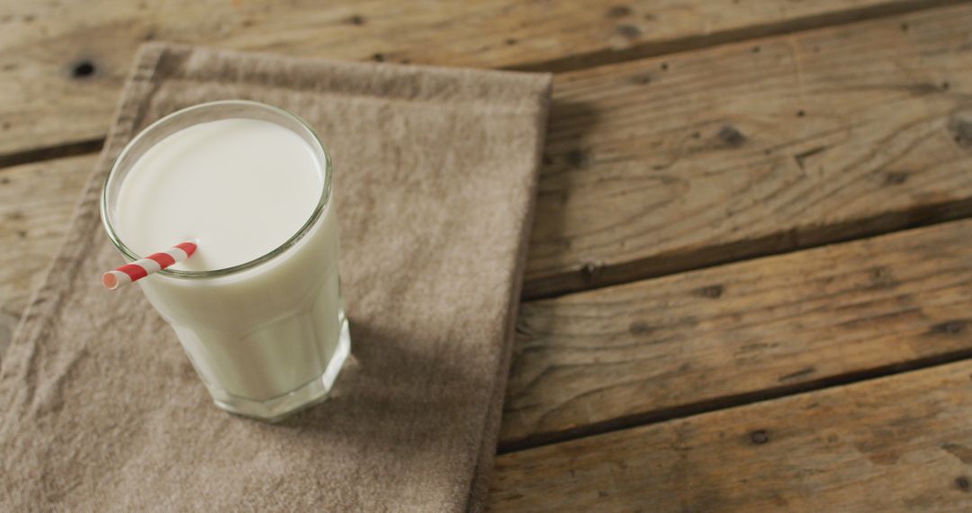 Glass of Fresh Milk on Wooden Table with Striped Straw - Free Images, Stock Photos and Pictures on Pikwizard.com