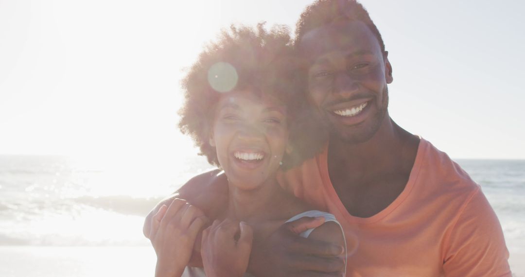 Smiling African American Couple Hugging on Sunny Beach - Free Images, Stock Photos and Pictures on Pikwizard.com