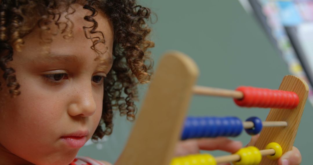 Child Learning Math Using Colorful Abacus in Classroom